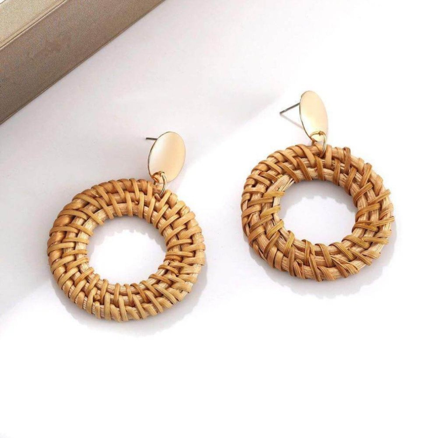 Lightweight rattan earrings adding a rustic touch.